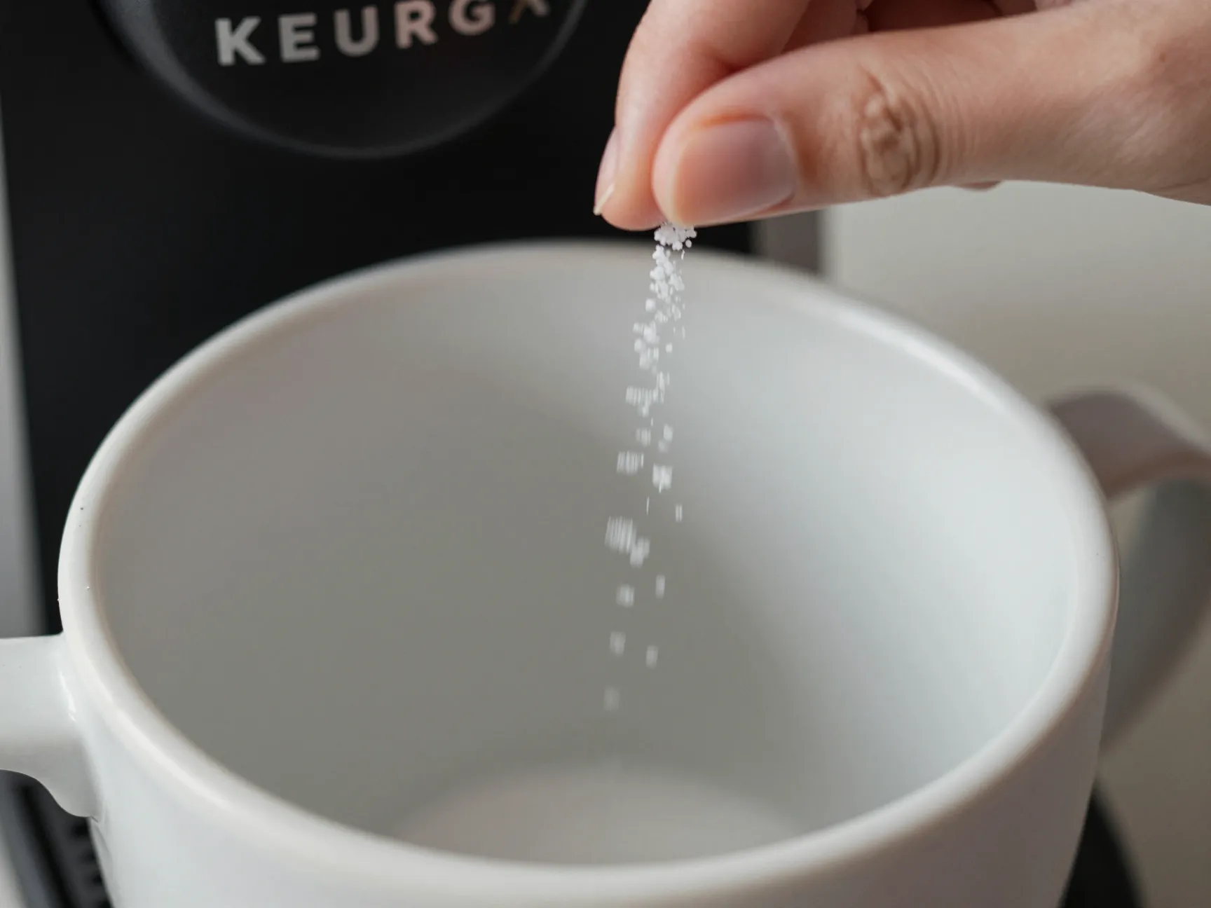 Tiny pinch of salt sprinkled into empty coffee mug
