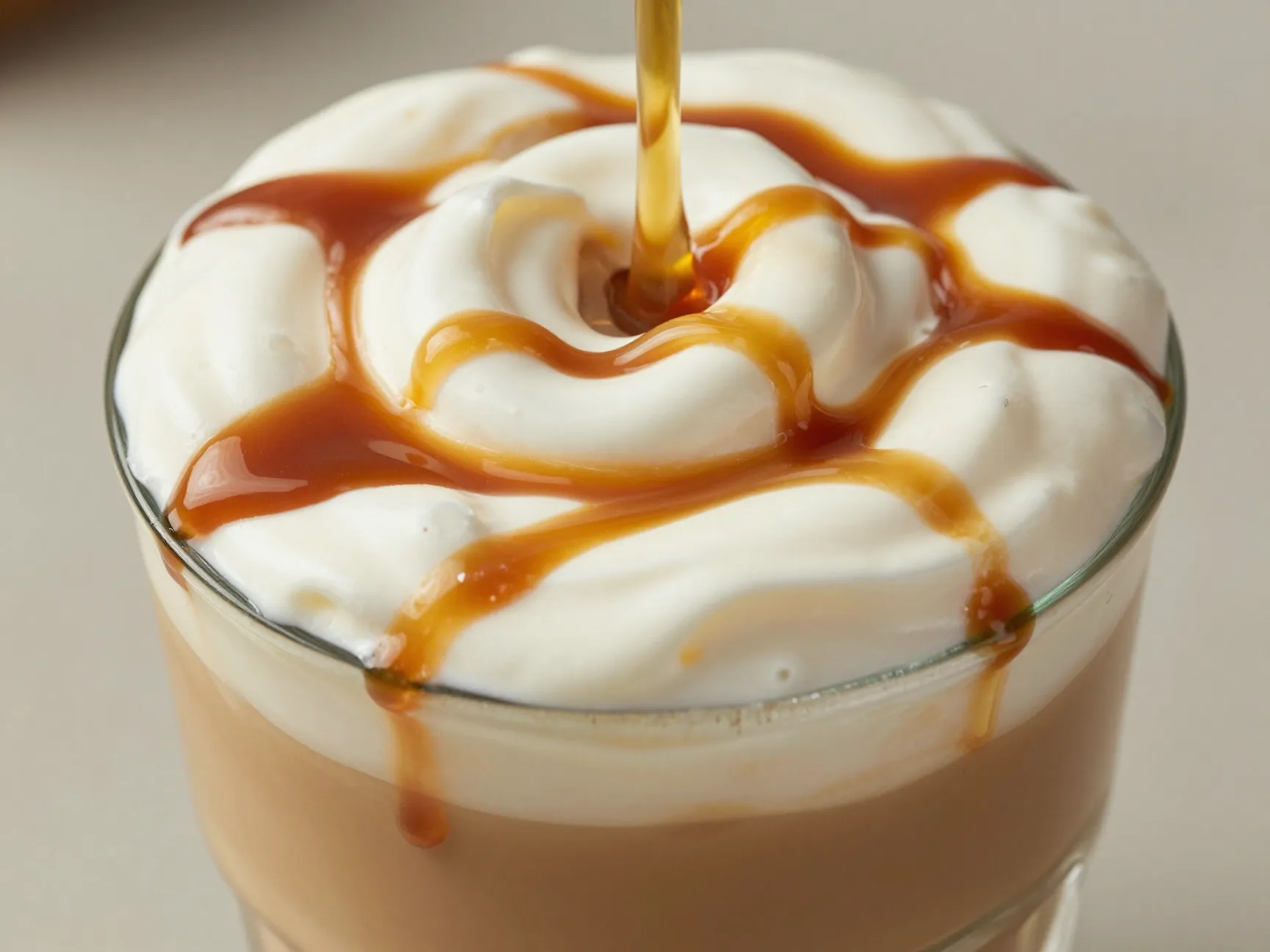 Indulgent iced vanilla sweet cream caramel macchiato with thick cream