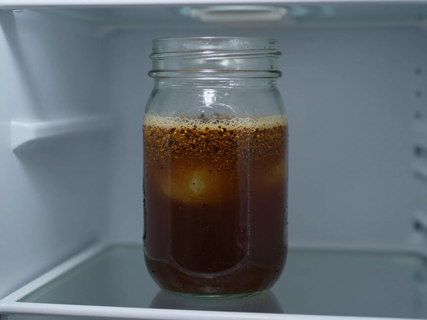 Cold brew concentrate steeping in jar coarse grounds