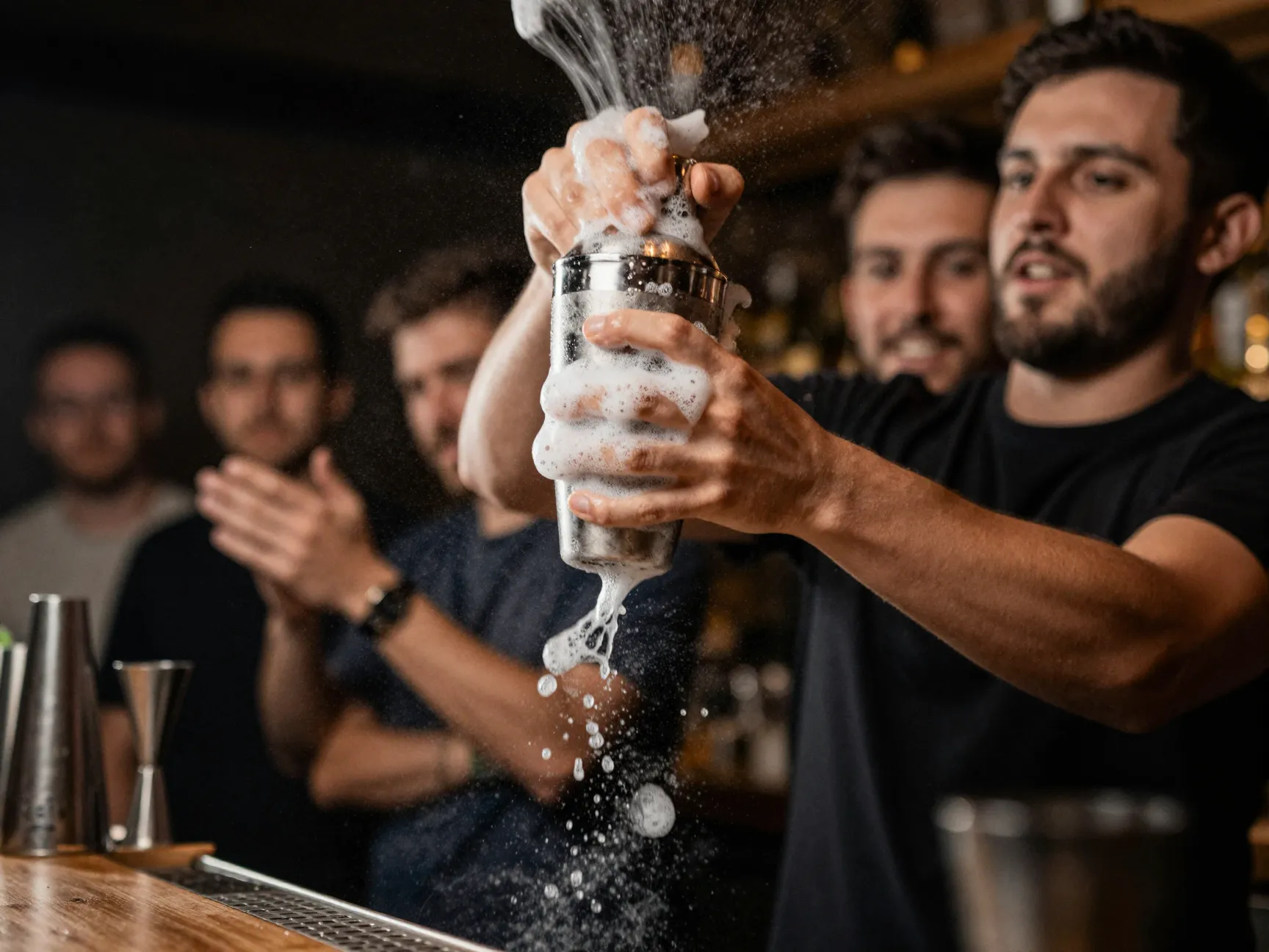 Bartender shaking cocktail shaker vigorously for foam creation