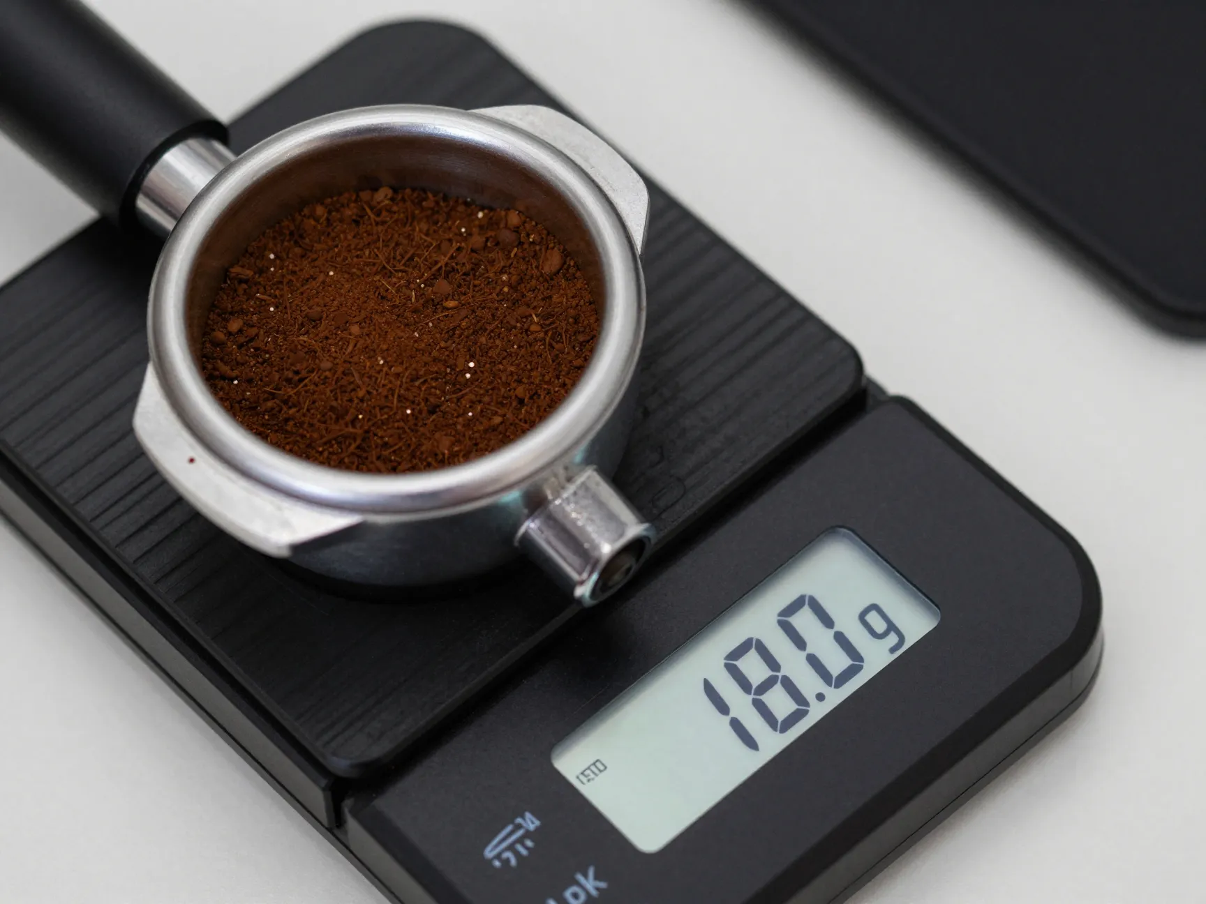 Precision scale measuring coffee dose in portafilter with digital readout