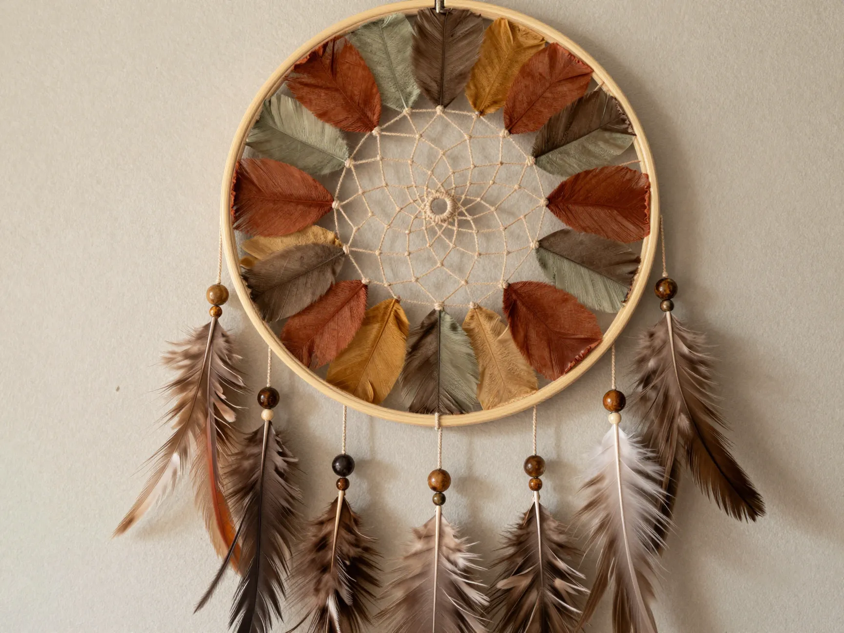 Earth toned coffee filter dream catcher with yarn web beads and feathers
