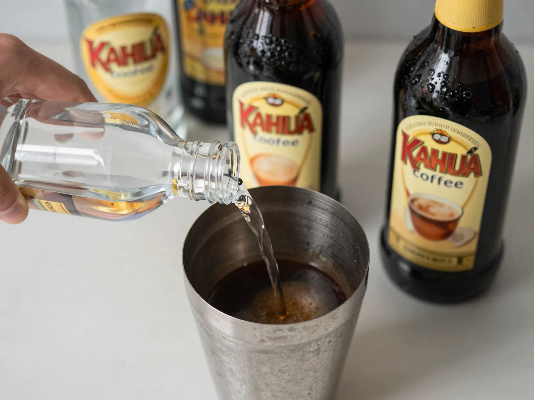 Measuring vodka kahlua and espresso into cocktail shaker