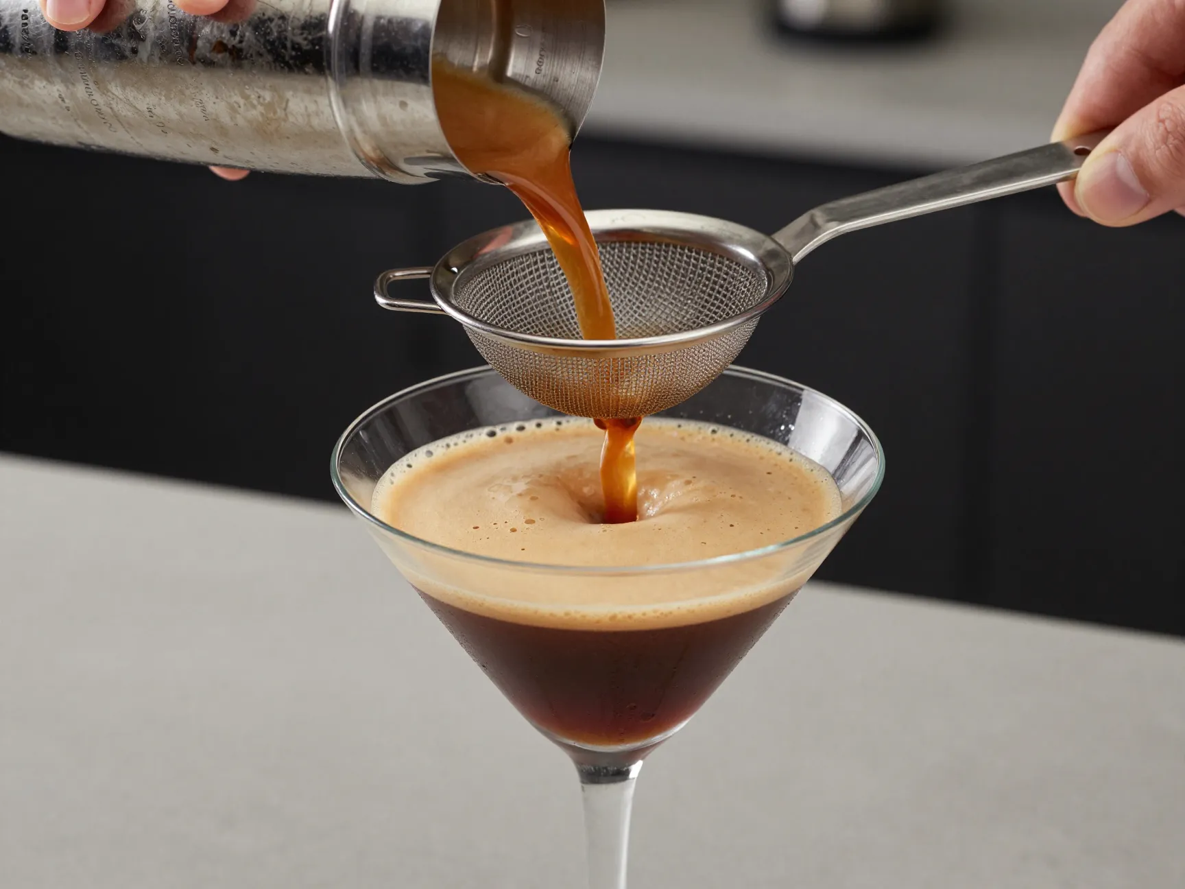 Double straining cocktail into chilled martini glass