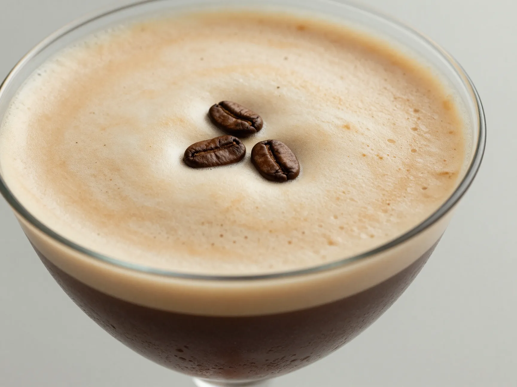 Three coffee beans garnish on espresso martini foam