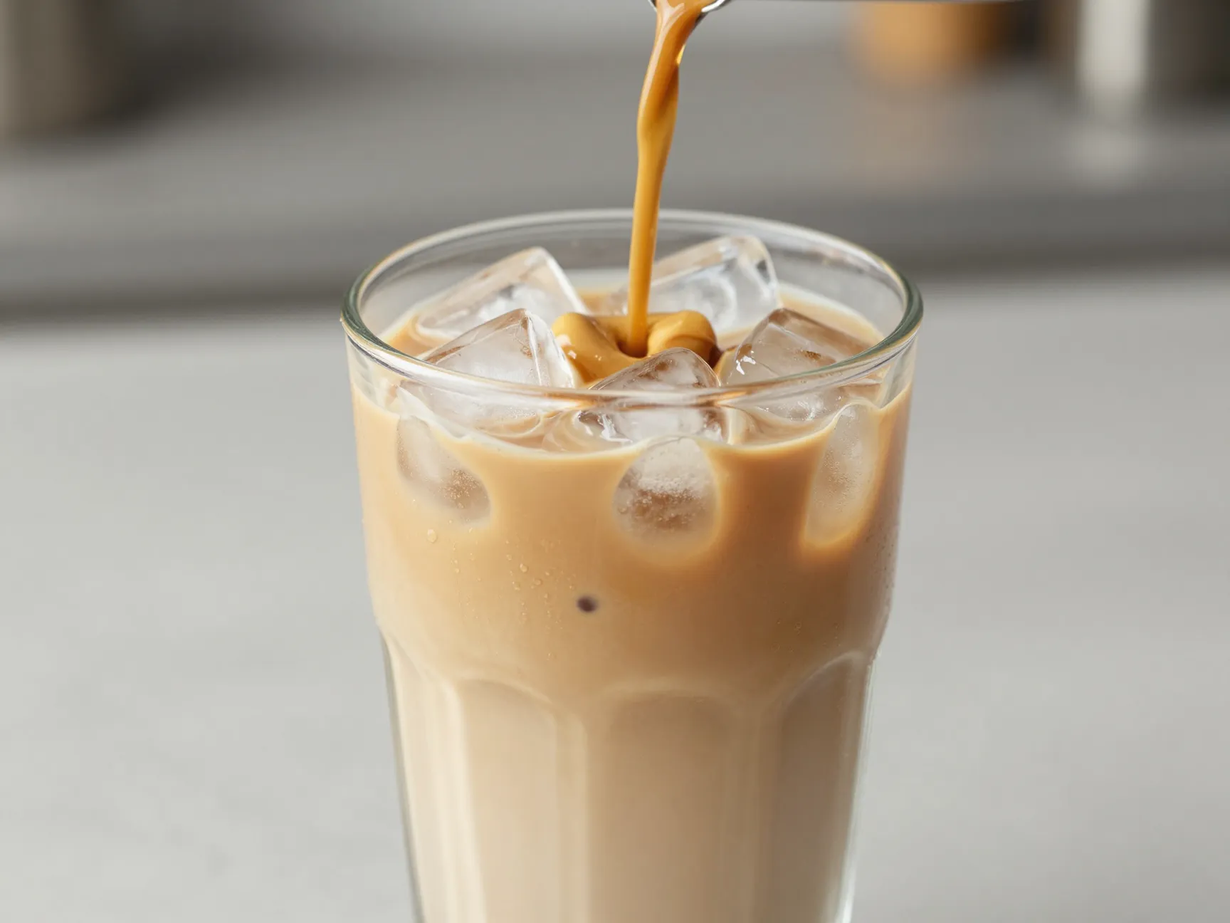 Blonde espresso poured over ice in clear tall glass