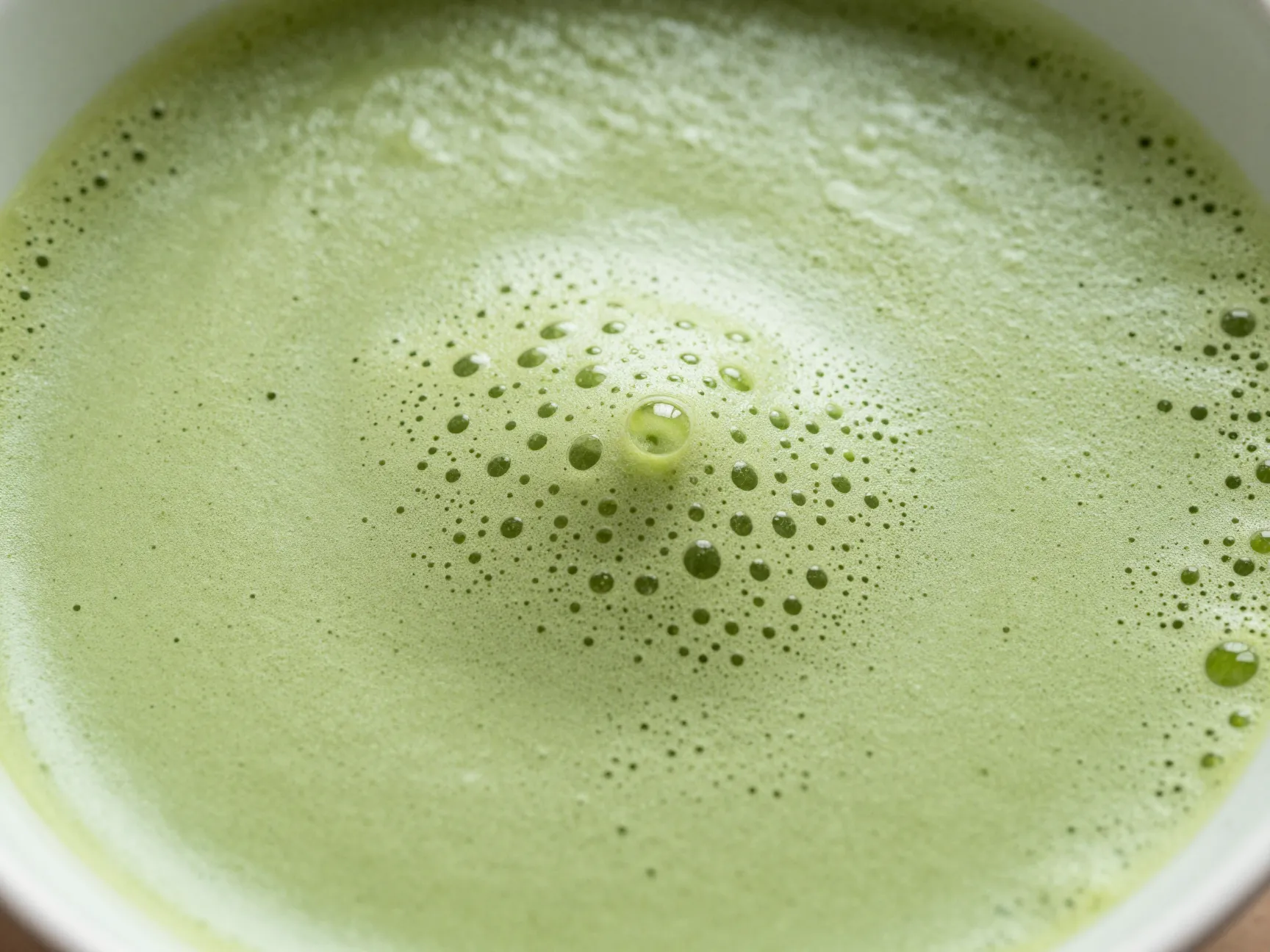 Closeup of perfect matcha foam with fine creamy micro bubbles