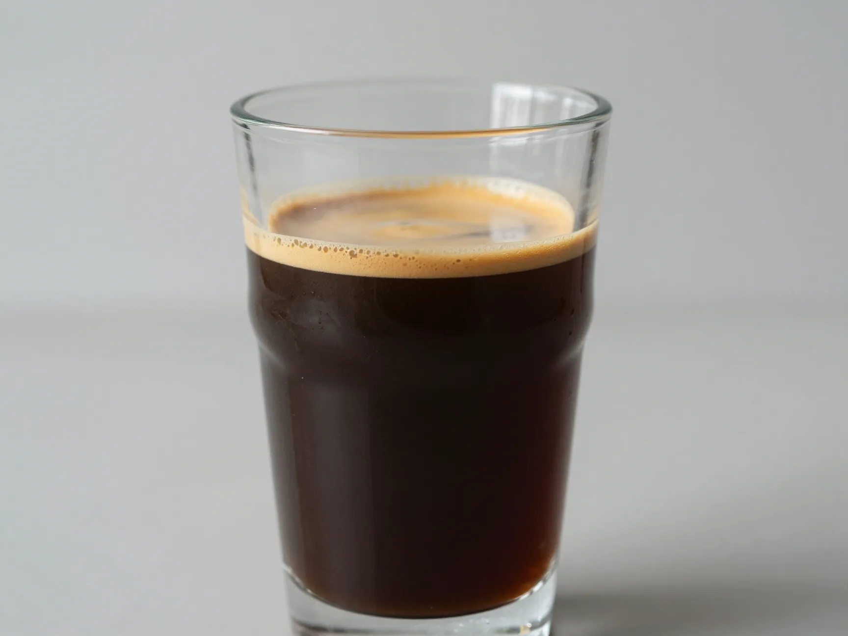 Americano with golden crema layer in hot water clear glass