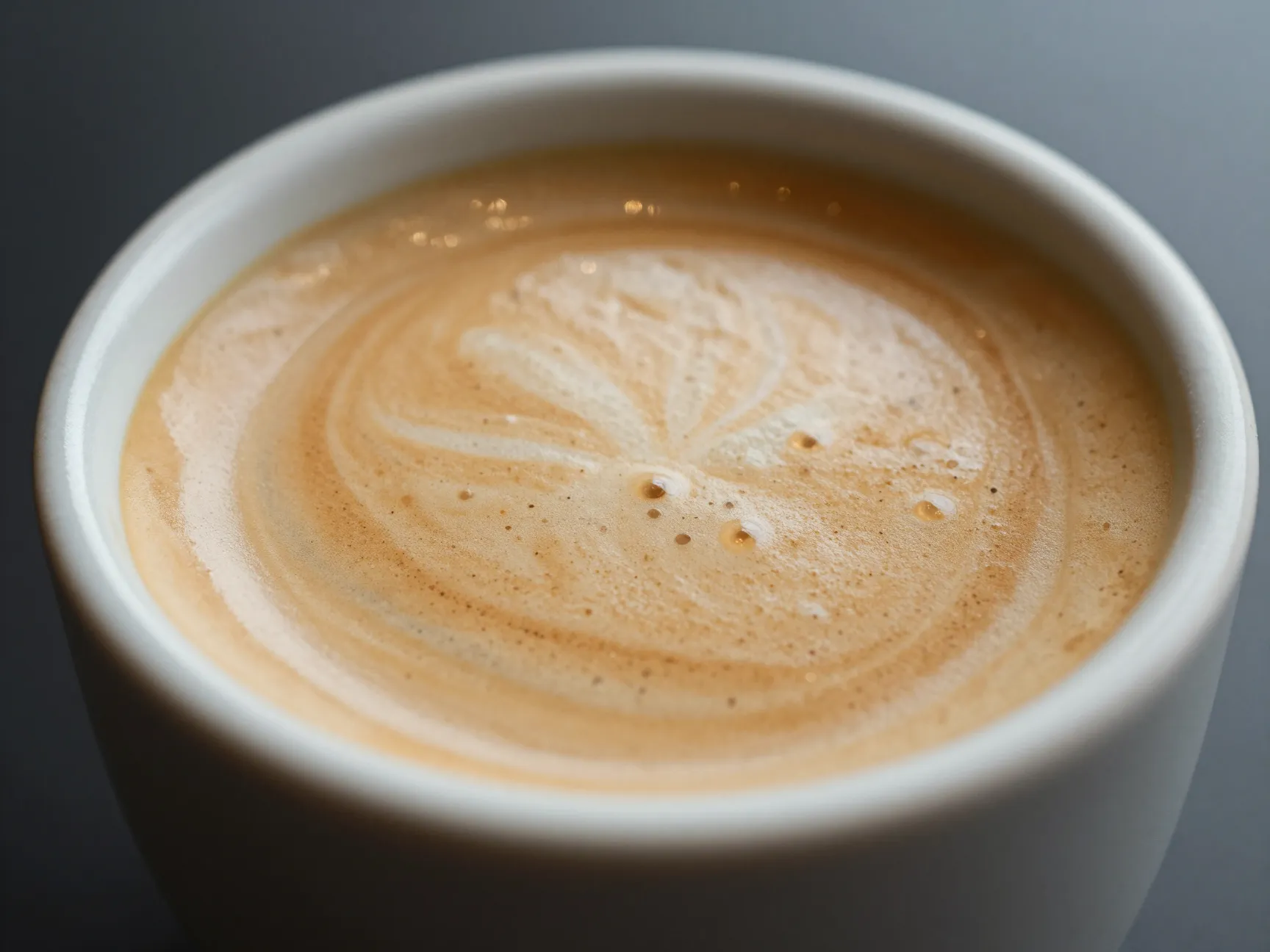 A flat white coffee with velvety microfoam in a small ceramic cup