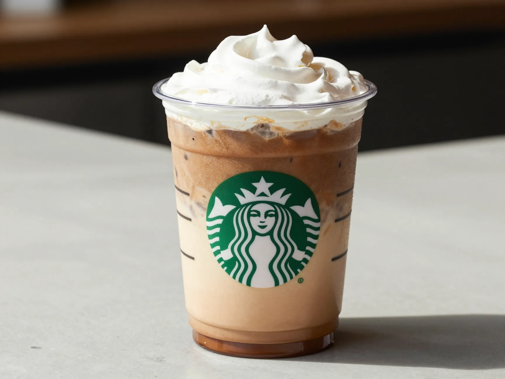 Iced layered white chocolate mocha in clear cup on marble