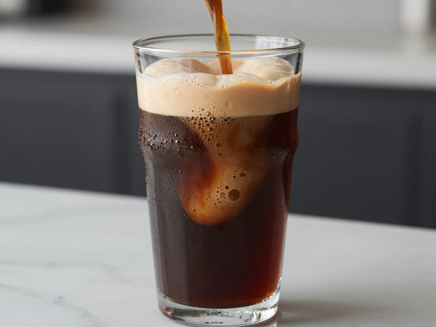 Creamy nitro cold brew cascade in glass tumbler