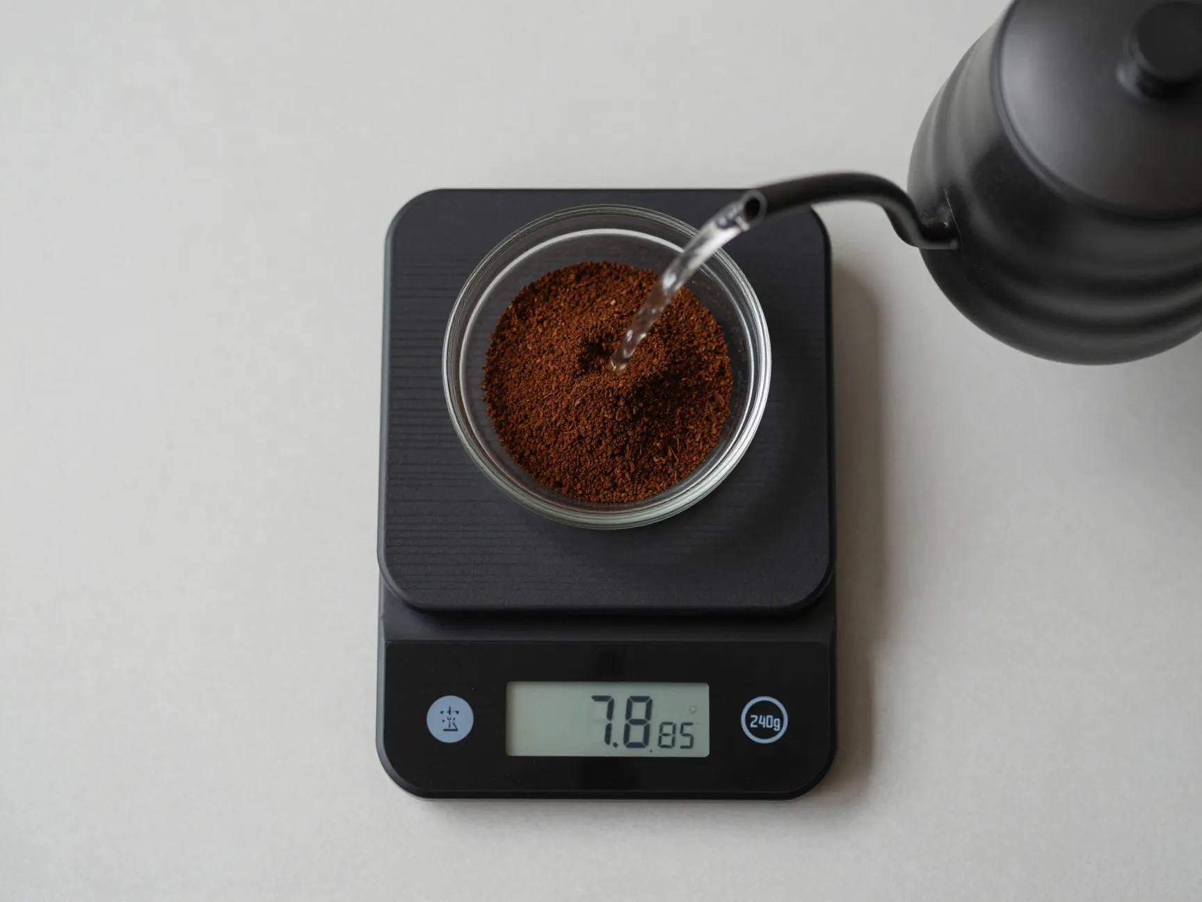 Digital kitchen scale measuring coffee grounds and water golden ratio