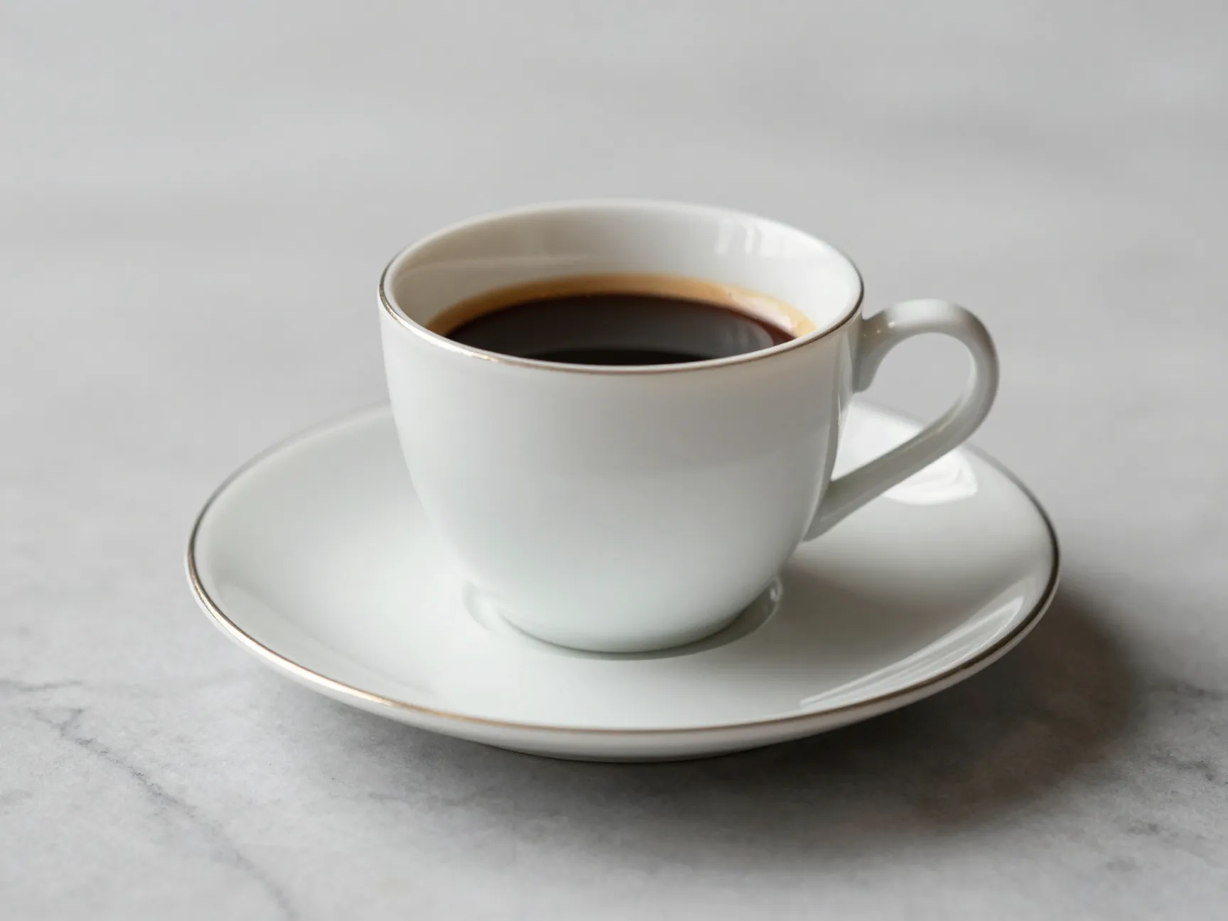 An elegant porcelain espresso cup and saucer set on a marble surface