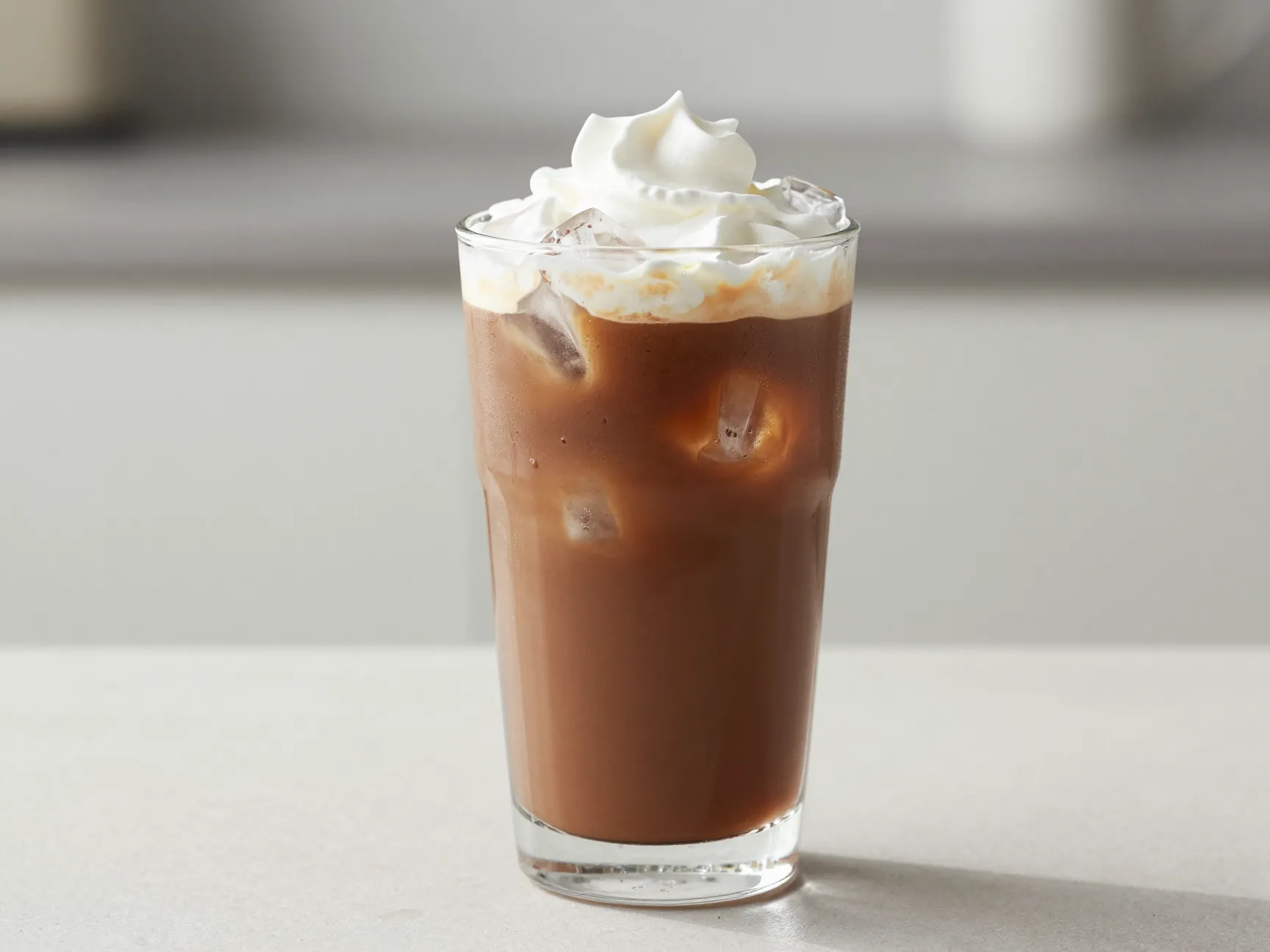 Cold brew mocha latte in tall glass with ice cubes optional whipped cream
