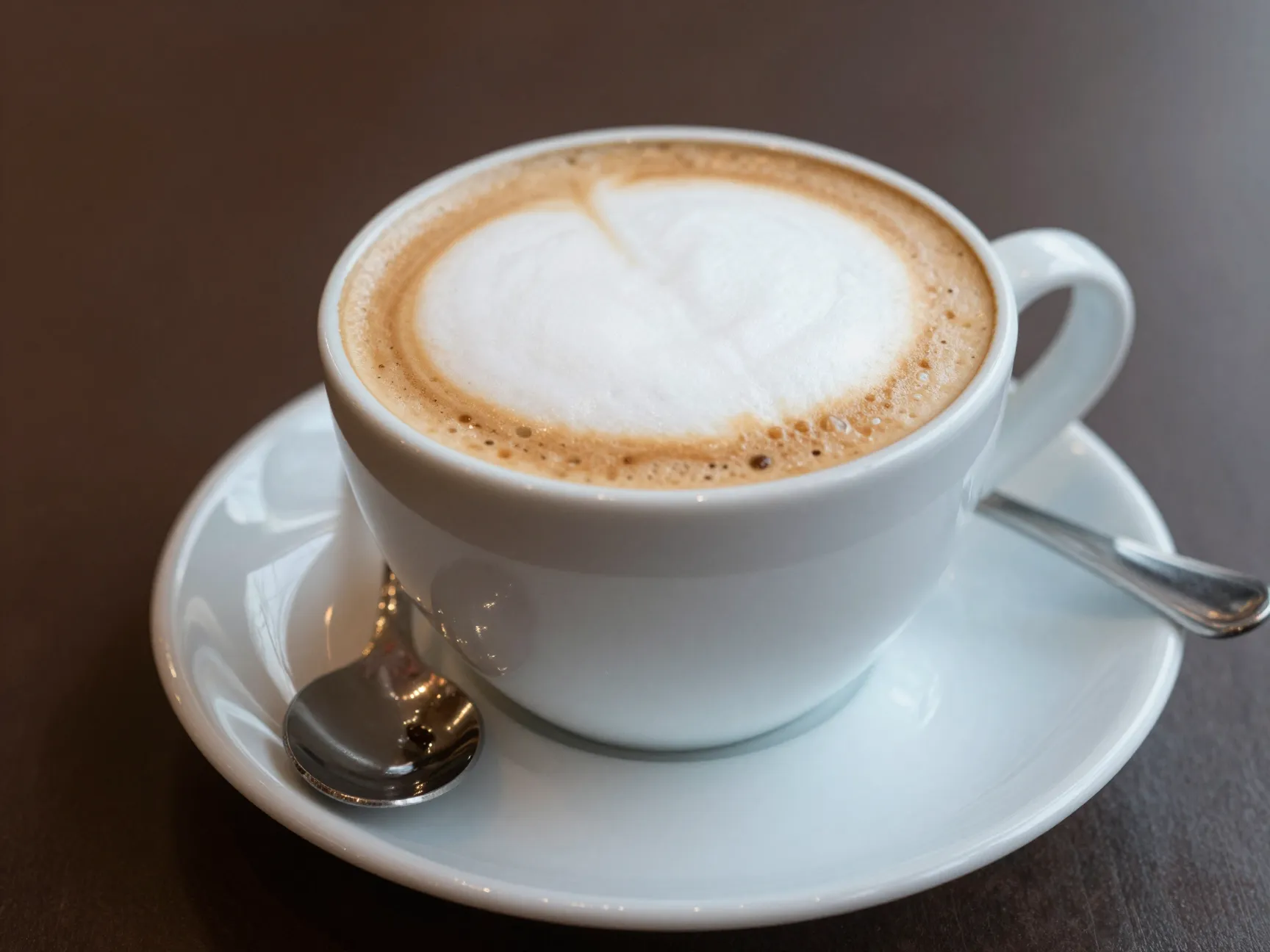 Traditional cappuccino in thirds with thick foam in ceramic cup