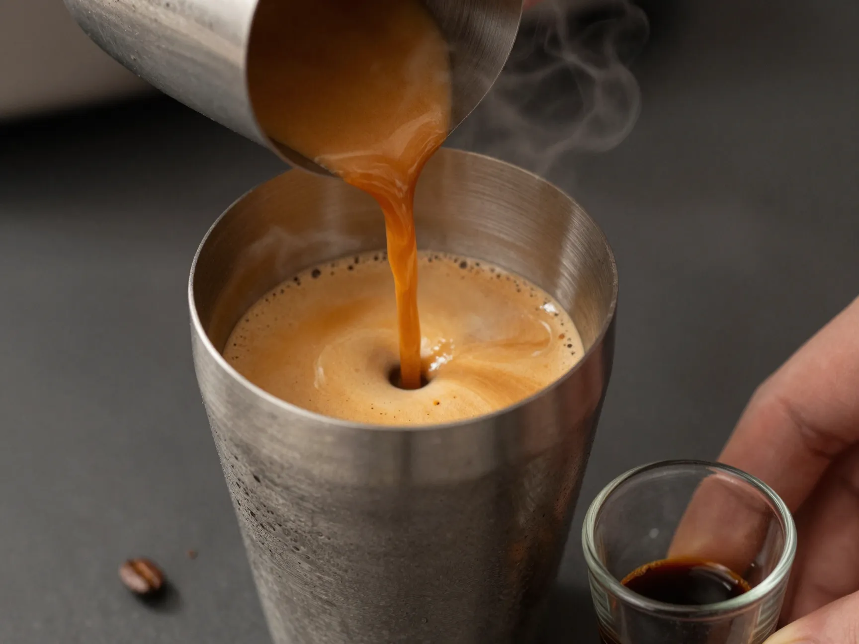 Fresh espresso shot poured into cocktail shaker with crema