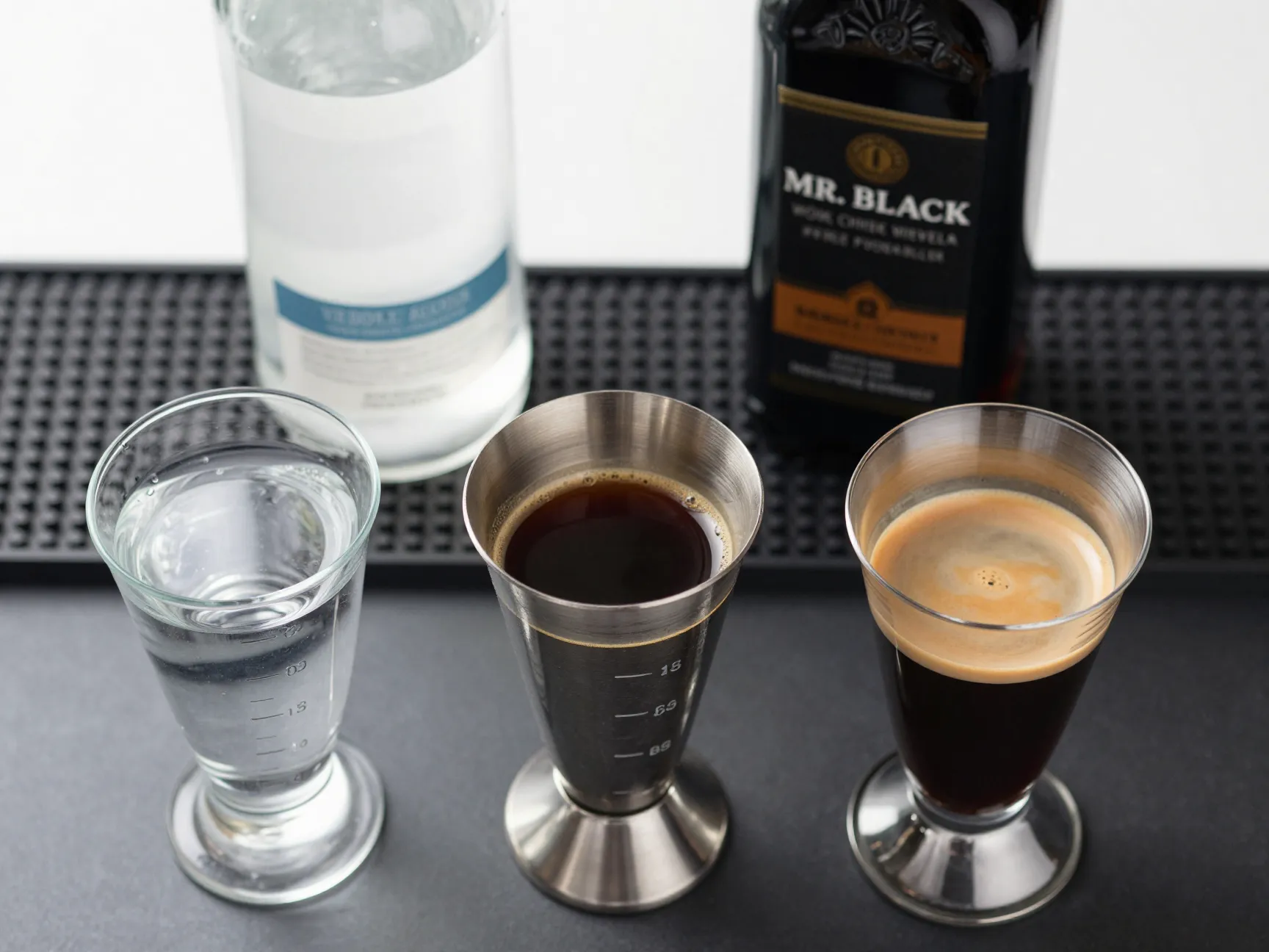 Three equal parts of vodka coffee liqueur and espresso in jiggers