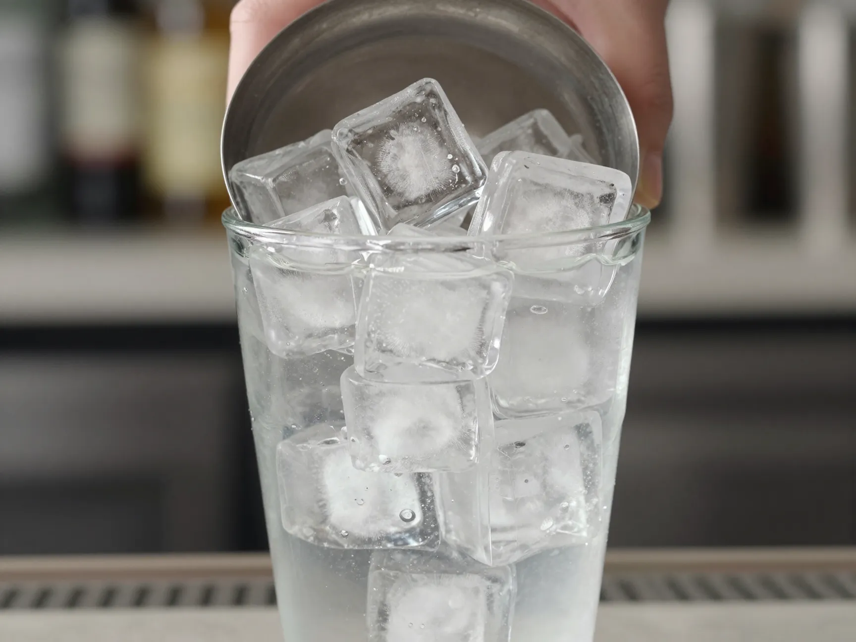 Cocktail shaker two thirds full of large clear ice cubes