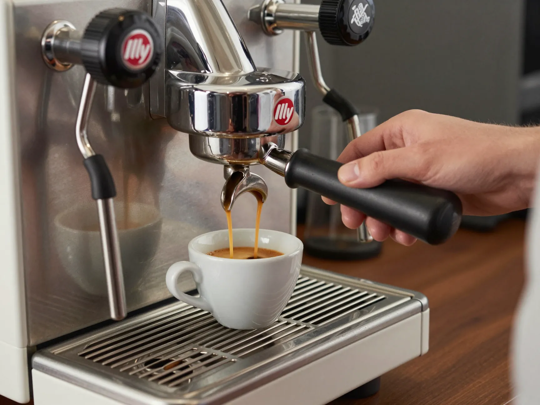 Barista pulling illy espresso shot on premium commercial machine