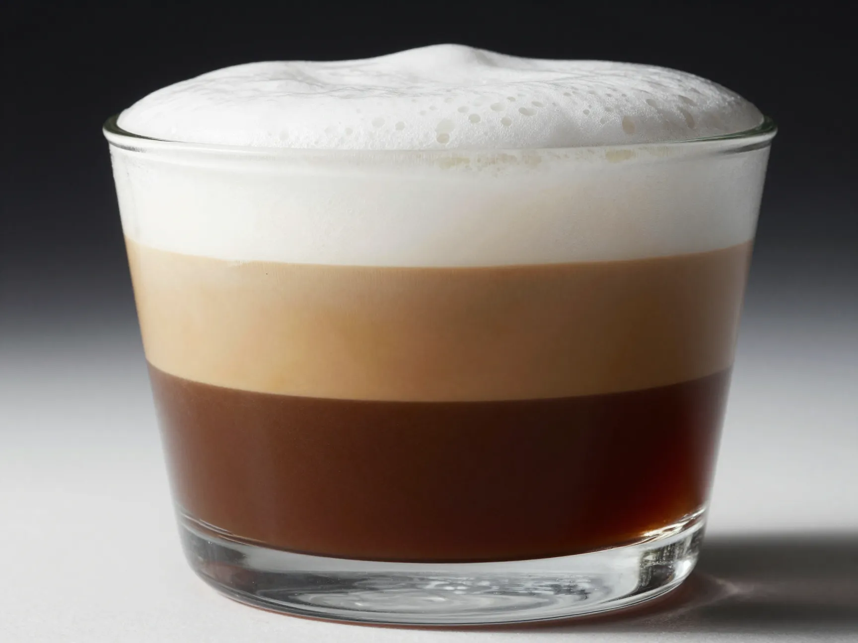 Three distinct layers espresso milk foam in a cappuccino cross section