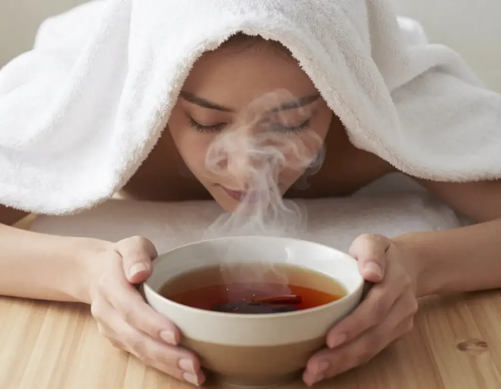 Aromatherapy steam treatment with bowl of cinnamon tea